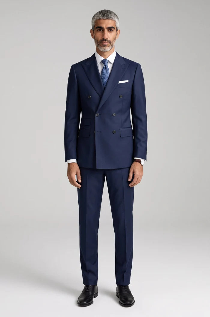 Men's Blutailor Belgravia Navy Double-Breasted Suit from the Luxury Collection, crafted from 100% non-mulesed Super 100's wool, featuring a rich navy finish, sharp peak lapels, and matching tailored trousers for timeless elegance and refined formal sophistication.