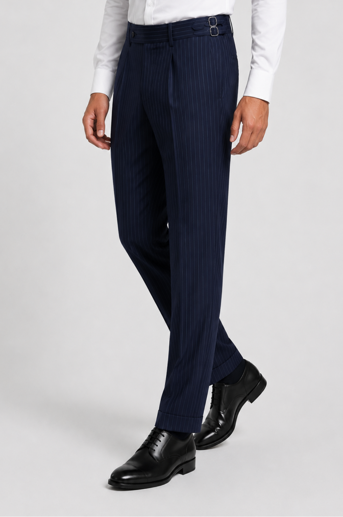 Men's Blutailor Sovereign Navy Pinstripe Gurkha Pant crafted from premium terry rayon fabric, featuring a sophisticated navy blue base with classic pinstripe detailing, a high-waisted Gurkha-style waistband with adjustable side fasteners, double-pleated front, tailored tapered silhouette, and a refined aesthetic ideal for formal wear, business attire, weddings, and elevated occasion dressing.