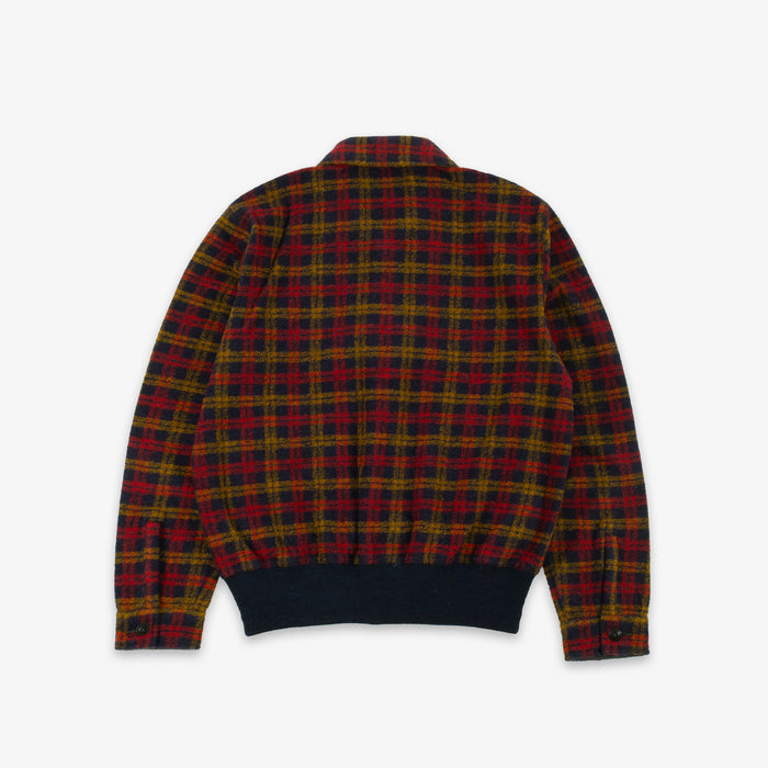 A long-sleeve plaid jacket shown from the back, featuring a red, yellow, and black tartan pattern with a solid dark navy ribbed hem and cuffs, displayed on a light gray background.