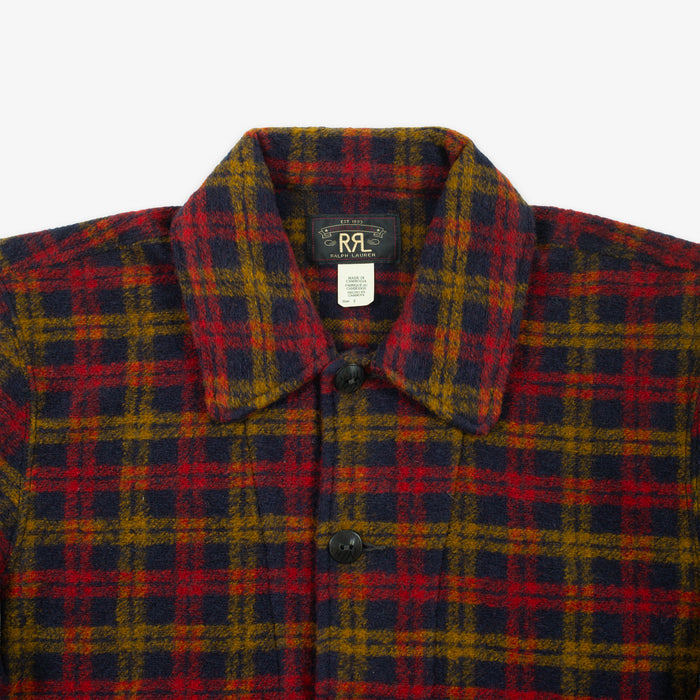 A close-up of a plaid button-up shirt collar with a red, navy, and mustard yellow pattern, featuring a black button and an RL interior label.